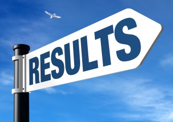 A blue sky with a street sign shown up close with the word "RESULTS" on an arrow shaped sign